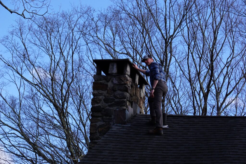 Inspector checking the chimney on a roof